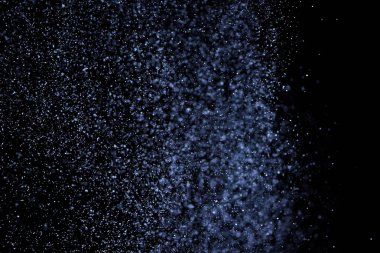 Siyah arka plan üzerine su sıçramalarına soyut mavi. Beyaz parçacıkların hareket dondurmak. Yağmur, kar doku yerleşimi..