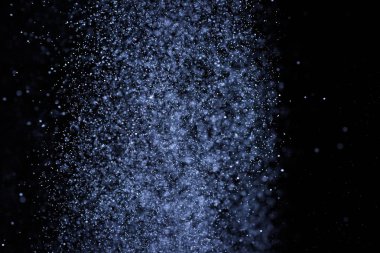Siyah arka plan üzerine su sıçramalarına soyut mavi. Beyaz parçacıkların hareket dondurmak. Yağmur, kar doku yerleşimi..