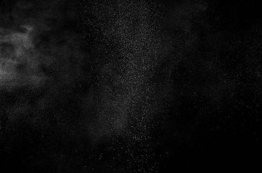 Siyah zemin üzerindeki beyaz parçacıkların hareketlerini dondur. Barut patlaması. Soyut toz tabakası dokusu.