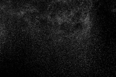 Siyah arka planda soyut su sıçramaları. Beyaz parçacıkların hareketlerini dondur. Yağmur, kar örtüsü dokusu.