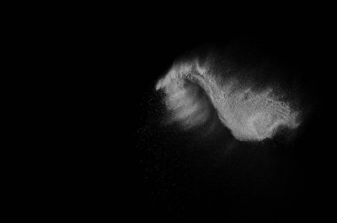 Siyah zemin üzerindeki beyaz parçacıkların hareketlerini dondur. Barut patlaması. Soyut toz tabakası dokusu.