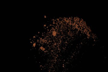 Toprak patlaması siyah arka planda izole edildi. Kahverengi zemin soyut bulutu.