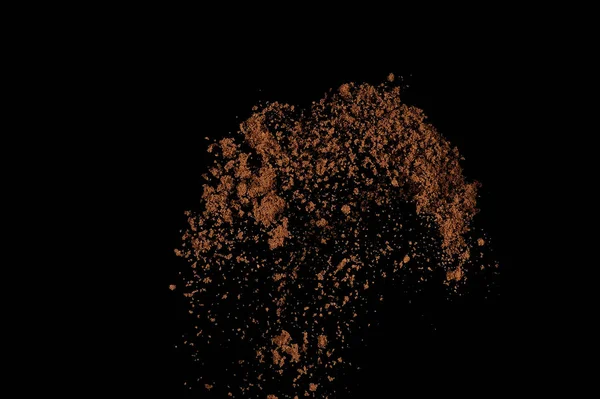 Toprak patlaması siyah arka planda izole edildi. Kahverengi zemin soyut bulutu.