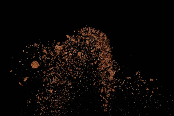 Toprak patlaması siyah arka planda izole edildi. Kahverengi zemin soyut bulutu.