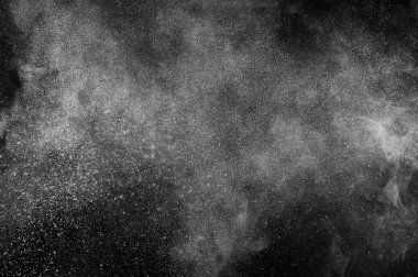 Siyah zemin üzerindeki beyaz parçacıkların hareketlerini dondur. Barut patlaması. Soyut toz tabakası dokusu. 