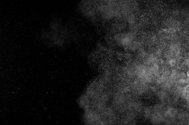 Siyah zemin üzerindeki beyaz parçacıkların hareketlerini dondur. Barut patlaması. Soyut toz tabakası dokusu. 