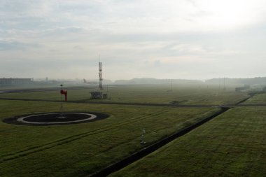 Badung/Bali-Nisan 14 2019: Ngurah Rai Airport Bali'de sabah saatlerinde gökyüzünün tam gri cirrus bulutları ve bir uçak iniş yaparken Meteoroloji bahçesinin manzarası