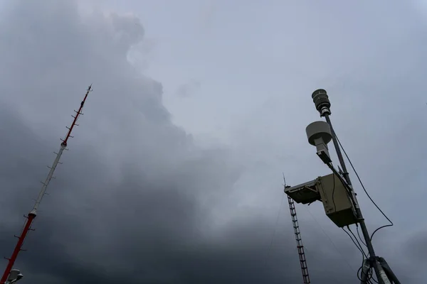 Station météorologique automatique portable à l'aéroport de Ngurah Rai sous les nuages sombres effrayants Cumulonimbus. Cet outil a une fonction pour mesurer les paramètres météorologiques tels que le vent, la pluie, la température, l'humidité — Photo