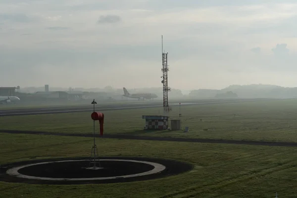 BADUNG / BALI-ABRIL 14 2019: Un paisaje de jardín meteorológico en el aeropuerto de Ngurah Rai Bali por la mañana cuando el cielo lleno de nubes de cirros grises y un avión está aterrizando —  Fotos de Stock