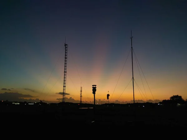 Incroyable lumière du matin orange dans le ciel bleu avec antenne de communication comme silhouette — Photo