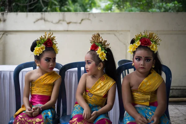 БАЛИ / ИНДОНЕЗИЯ-ДЕКАБРЬ 28 2017: Три молодых балийских танцора в традиционной балийской одежде и макияже готовились к выступлению на сцене. Один из них выглядит нервным. Это бесплатное мероприятие — стоковое фото