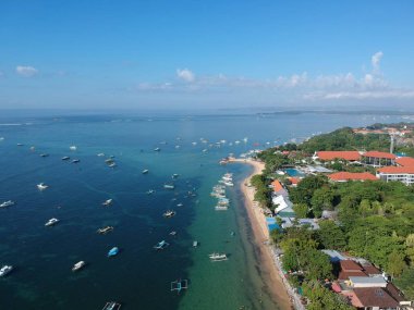 Sanur plajı, Bali inanılmaz bir hava görünümü. Plajın şekli benzersizdir ve plajda birkaç kulübe vardır. Deniz suyu berrak ve plaja bağlı birkaç geleneksel tekneler vardır