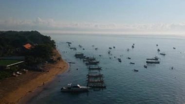 Sanur Plajı, Bali inanılmaz bir havadan görünümü. Plajın şekli benzersizdir ve deniz suyu açıktır ve plaja bağlı birçok geleneksel tekne vardır