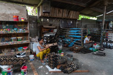 Ubud/Bali-Nisan 27 2019: Ubud'dan iki kadın zanaatkar koyu ve çekici renkler kullanılarak çizilmiş ve renkli maske el sanatları yapıyorlardı. Ubud Bali el sanatları üreticilerinden biridir