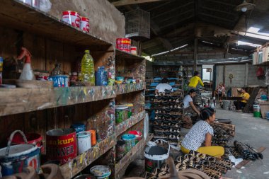Ubud/Bali-Nisan 27 2019: Ubud'lu kadın işçiler koyu ve çekici renkler kullanılarak çizilmiş ve renkli maske el sanatları yapıyorlardı. Ubud Bali el sanatları üreticilerinden biridir