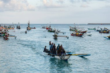 Jimbaran/Bali-May 15 2019: Bazı geleneksel Bali tekneleri Jimbaran denizi nde balık tutuyor. Bu geleneksel tekne renkli bayraklarla dekore edilmiştir.