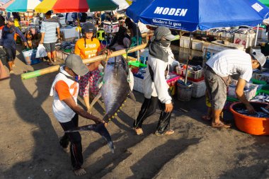 Bali/Endonezya-15 Mayıs 2019: Kedonganan-Bali balık pazarının atmosferi her büfede renkli şemsiyeler ile. Bazı balıkçılar büyük balık yakalar ile balıkçılık eve gitmek