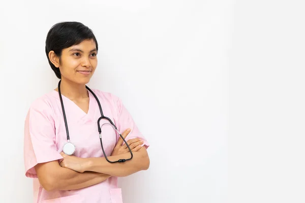 Asiatisk kvinnlig läkare med skott svart hår bär rosa uniform och har stetoskop på axeln. Självsäker och värme ser isolerad i vit bakgrund. Plats för text — Stockfoto