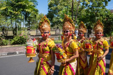 Denpasar/Bali-15 Haziran 2019: Bali Sanat Festivali 2019'un açılış töreninde geleneksel Bali başlığı ve geleneksel sarong giyen genç Balili kadınlar. Bu ücretsiz ve genel bir olaydır