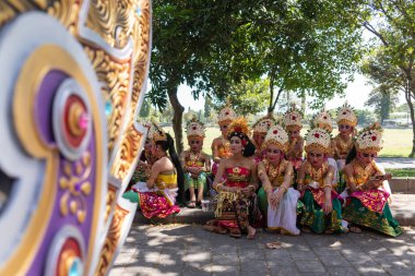 Denpasar/Bali-15 Haziran 2019: Bali Sanat Festivali 2019'un açılış töreninde geleneksel Bali başlığı ve geleneksel sarong giyen genç Balili kadınlar. Bu ücretsiz ve genel bir olaydır