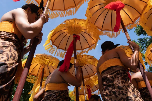 Grupp av balinesiska dansare i etniska kostymer med traditionella färgglada paraplyer på hinduisk ceremoni parad under Temple Festival. Balinesiska folkkultur — Stockfoto