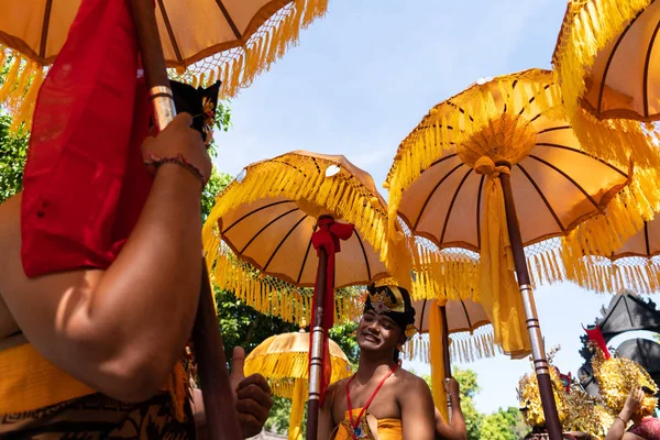 DENPASAR / INDONÉSIA-JUNHO 15 2019: Grupo de dançarinos balineses em trajes étnicos com guarda-chuvas coloridos tradicionais em desfile de cerimônia hindu durante o festival do templo. Cultura dos povos balineses — Fotografia de Stock