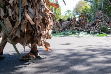 Denpasar/Bali-15 Haziran 2019: Barış Memedi veya Keraras, kurutulmuş muz yapraklarından yapılmış kostümlerle dans. İnsanların ruhlarını cennete tanıtan büyülü bir danstır. Genel ve ücretsiz etkinlik
