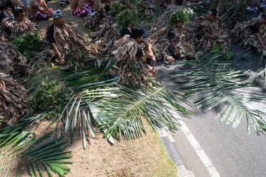 Denpasar/Bali-15 Haziran 2019: Barış Memedi veya Keraras, kurutulmuş muz yapraklarından yapılmış kostümlerle dans. İnsanların ruhlarını cennete tanıtan büyülü bir danstır. Genel ve ücretsiz etkinlik