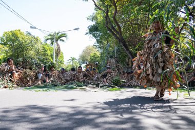 Denpasar/Bali-15 Haziran 2019: Barış Memedi veya Keraras, kurutulmuş muz yapraklarından yapılmış kostümlerle dans. İnsanların ruhlarını cennete tanıtan büyülü bir danstır. Genel ve ücretsiz etkinlik
