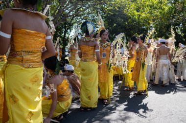 Denpasar/Bali-15 Haziran 2019: Sarı ve beyaz Bali geleneksel kostümünü giyen Sampian Dancer, Bali Sanat Festivali 2019'da sahne almaya hazırlanıyor. Onlar perfo içinde süs için palmiye yaprakları kullanın