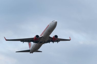 Denpasar,Bali/Endonezya-08 Haziran 2019: Aslan lı uçak Ngurah Rai Uluslararası Havaalanı Bali'den uçuyor, gökyüzü bulutlu gri