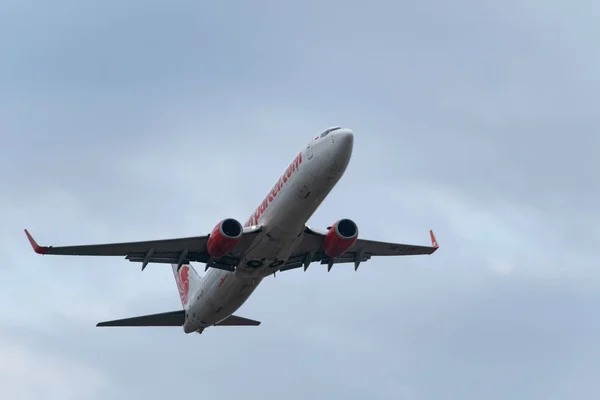 Denpasar,Bali/Endonezya-08 Haziran 2019: Aslan lı uçak Ngurah Rai Uluslararası Havaalanı Bali'den uçuyor, gökyüzü bulutlu gri — Stok fotoğraf