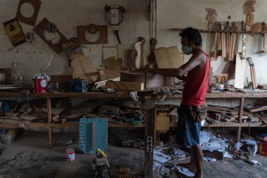Gianyar,Bali/Endonezya-30 Mayıs 2019: Bir gitar ustası Guwang Village, Gianyar, Bali'de I Wayan Tuges'e ait ahşap gitar atölyesinde ahşaptan klasik gitarlar yapıyor.