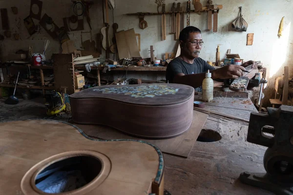 GIANYAR, BALI / INDONESIA-MAGGIO 30 2019: Un artigiano della chitarra sta misurando e si assicura che sia una parte di chitarra di precisione, in un laboratorio di chitarra in legno di proprietà di I Wayan Tuges a Guwang Village, Gianyar, Bali — Foto Stock