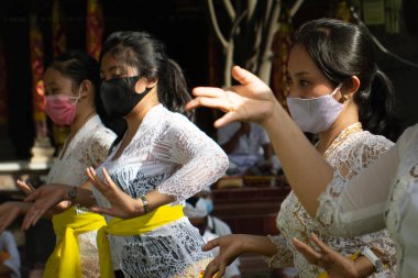Bali / INDONEZYA-JULY 3 Temmuz 2020: Bali 'deki Yeni Normal Yaşam. Tapınaktaki dua programına COVID-19 'un yayılmasını önlemek için dansçıların sağlık maskesi taktıkları geleneksel bir dans eşlik ediyor.