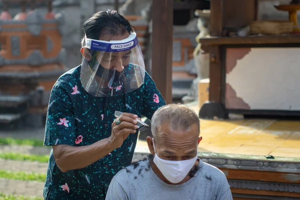 a barber is doing home service. The COVID-19 pandemic has caused many businesses to close. To stay afloat, entrepreneurs prefer to go to customers. Stick to health protocols for new normal life