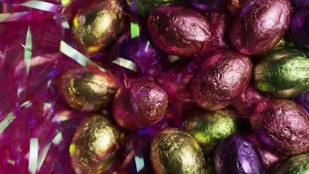 Colpo rotante di caramelle pasquali colorate su un letto di erba pasquale — Video Stock