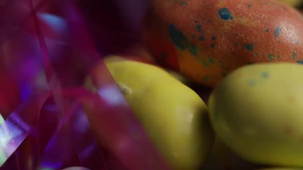 Roterende shot van kleurrijke Pasen snoepjes op een bed van Pasen gras — Stockvideo