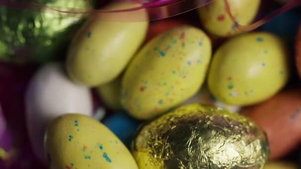 Drehschuss von bunten Osterbonbons auf einem Bett aus Ostergras — Stockvideo