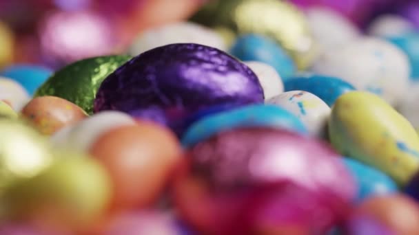 Rotación de caramelos de Pascua de colores en una cama de pasto de Pascua — Vídeos de Stock