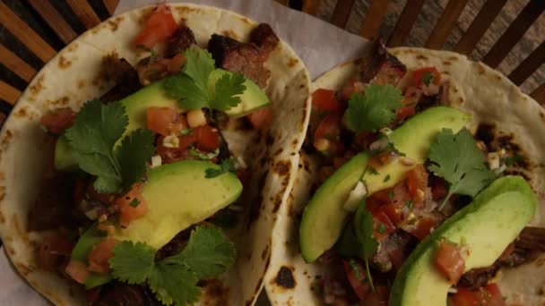 Tiro giratorio de deliciosos tacos sobre una superficie de madera — Vídeo de stock