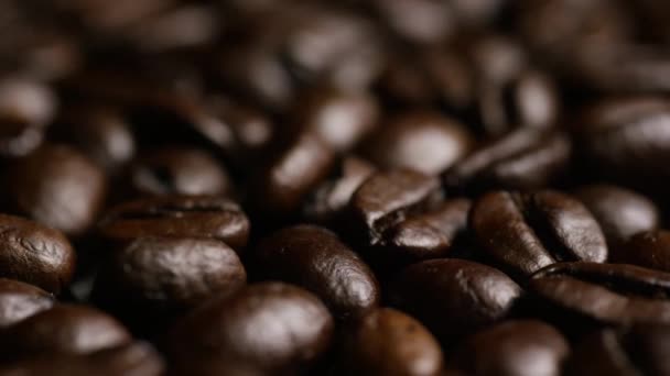 Tomada rotativa de deliciosos grãos de café torrados em uma superfície branca — Vídeo de Stock