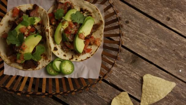 Tiro giratorio de deliciosos tacos sobre una superficie de madera — Vídeos de Stock