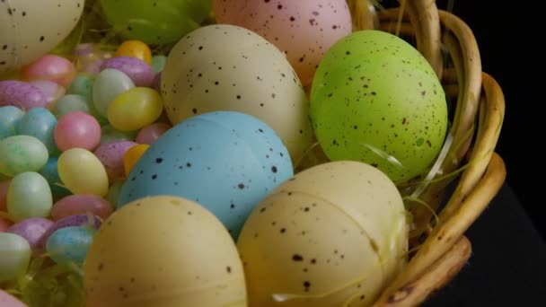 Tiro giratorio de decoraciones de Pascua y dulces en la hierba de Pascua colorida — Vídeo de stock