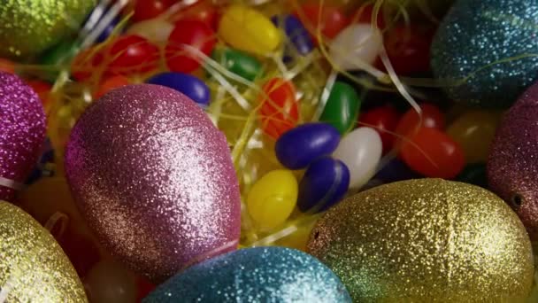 Rotating shot of Easter decorations and candy in colorful Easter grass — Stock Video