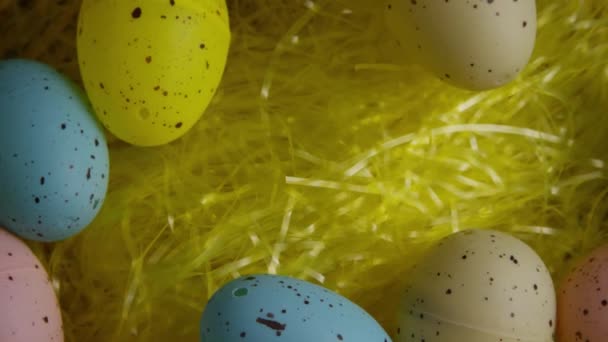 Вращающийся кадр пасхальных украшений и конфет в красочной пасхальной траве — стоковое видео