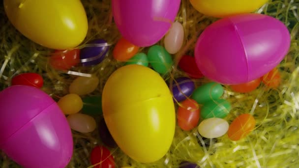 Rotativa tiro de decorações de Páscoa e doces na grama de Páscoa colorida — Vídeo de Stock
