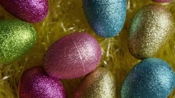 Obrotowy strzał Wielkanocnych dekoracji i cukierków w kolorowych trawie Wielkanocnej — Wideo stockowe
