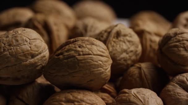 Rotační střípek vlašských ořechů v jejich mušle na bílém povrchu — Stock video