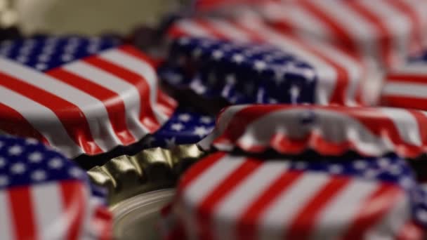 Tiro rotativo de tampas de garrafa com a bandeira americana impressa neles — Vídeo de Stock